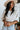Front view of model wearing The Right Cord Top features lightweight cream-colored corduroy, a round neckline, 3/4 sleeves with elastic wrists, a keyhole button back, and a back zipper