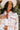 Front view of model wearing The Pretty In Pink Jacket features a pink wool material, an ivory plaid pattern, a collar neck, a button-up front, long cuffed sleeves, two front pockets, and a cropped fit.