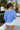 Back view of model wearing The Blake Cropped Sweatshirt In Indigo features knit fabric with a soft fleece interior, a round neckline, long batwing sleeves, and a wide cropped fit.