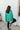 Back view of model wearing The Best Of Luck Sweatshirt In Green features knit fabric with terrycloth paneling, long raglan sleeves, raw hem details, and a high-low hemline with side slits