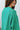 Side view of model wearing The Best Of Luck Sweatshirt In Green features knit fabric with terrycloth paneling, long raglan sleeves, raw hem details, and a high-low hemline with side slits