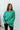 Front view of model wearing The Best Of Luck Sweatshirt In Green features knit fabric with terrycloth paneling, long raglan sleeves, raw hem details, and a high-low hemline with side slits
