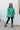 Front view of model wearing The Best Of Luck Sweatshirt In Green features knit fabric with terrycloth paneling, long raglan sleeves, raw hem details, and a high-low hemline with side slits