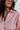 Close-up front view of model wearing the All My Love Faux-Leather Top, which features a pink faux-leather material, a collar neck, a V neckline, long cuffed sleeves, a curved bottom hem, and an oversized fit.