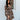 Front view of model wearing the I Like Your Vibe Floral Dress, which features a brown chiffon material, a taupe floral print, a curved neckline, long sleeves, a tier design with ruffles, a smocked back, and a mini length