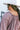 Close-up back view of model wearing the Long Time Coming Dress, which features washed purple fabric, three-quarter sleeves with elastic wrists, a v-neckline, and a flowy tiered body