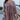 Front view of model wearing the Long Time Coming Dress, which features washed purple fabric, three-quarter sleeves with elastic wrists, a v-neckline, and a flowy tiered body