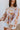 Front view of model wearing the In The Groove Top, which features a blue, pink, orange, and yellow floral print, long balloon sleeves with elastic trim , a square neckline, and a flowy babydoll fit