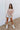 Full body front view of model wearing the In The Groove Top, which features a blue, pink, orange, and yellow floral print, long balloon sleeves with elastic trim , a square neckline, and a flowy babydoll fit