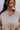 Close-up front view of model wearing the Get Cozy Top, which features a sand-colored knit material, a collar neck, a 3/4 button-up front, long sleeves, and a loose fit. 