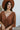 Close-up front view of model wearing the Spice It Up Dress, which features camel-colored fabric, a v-neckline with a cutout, a v-back with a tie, half sleeves, and a flowy fit
