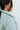 Close-up back view of model wearing the Breckenridge Jacket, which features a green colored material, a stitched quilt design, a high neck, long sleeves with a cinching at the wrist, two front pockets, and a front zipper closure
