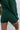 Close-up back view of model wearing the Headed North Shorts, which feature hunter green fabric with horizontal stitched stripes and an elastic waist