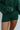 Close-up front view of model wearing the Headed North Shorts, which feature hunter green fabric with horizontal stitched stripes and an elastic waist