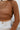 Close-up front view of model wearing the West Coast Sweater, which features open-knit fabric, a round rolled-hem neckline, long sleeves with ribbed elastic wrists, and a cropped back with a tie at the hemline