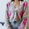 Front view of the Full Bloom Cardigan, which features a grey colored knit material, a multi-colored floral pattern, a V neckline, a button-up front, and long sleeves
