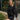 Close view of model wearing The Call Me Rhinestone Fringe Dress which features black sweatshirt material, rhinestone fringe across the back and sleeves, a round neckline, and long sleeves with ribbed cuffs.