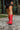 Front  view of model kicking with The Red Hot Western Boot which features faux leather, western stitching, and a 2" heel. These boots run small, we suggest sizing up half a size! 