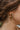 Close-up image of model wearing the Rainbow Road Hoop Earring, which features open gold hoops with a row of multi-colored rhinestones.