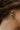 Close-up image of model wearing the Rainbow Road Hoop Earring, which features open gold hoops with a row of multi-colored rhinestones.