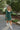 Full front view of model wearing The Juliet Plaid Dress which features monochromatic green plaid, a smocked top with a sweetheart neckline and bustier cups, long sleeves with elastic wrists, and a lined skirt.