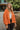 Front view of model wearing the Good Morning Teddy Jacket in Rust, that has orange sherpa fabric with corduroy accents, a zip-up front, a front zipper pocket, and long sleeves. Worn unzipped over white top.