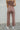 Full body back view of model wearing The Work It Out Tie Pant which features soft mocha-colored ribbed fabric, an elastic drawstring waist, and wide legs with side slits.