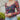 Close up view of model wearing The Slow Down Top which features black mesh fabric with a multi-colored floral print, a lined bodice, a corset front with hook and eye closures, and long sleeves with elastic shoulders.