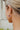 Close-up side image of model wearing the Lost In Space Earring, which features gold open star hoops with a pink, navy, white, and gold cluster of rhinestones inside.