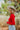 Side view of model wearing the New Day Mock Neck Top, which features red ribbed knit fabric with a mock neckline, long sleeves, and a cropped waist