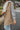 Close side view of model wearing The Ready to Go Shacket which features color-blocked grey and tan corduroy fabric, a button-up front with a collared neckline, long sleeves with buttoned wrists, front chest pockets, and side pockets.