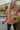 Close view of model wearing The Keep Me Warm Quilted Jacket which features quilted terracotta-colored fabric, two large front pockets, and a snap-up front with a collared neckline.