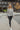 Full body view of model wearing The Count Me In Top which features grey waffle-knit fabric, a henley neckline with wooden buttons, raw hem details, and long sleeves.