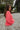Side view of model wearing The Cozy Chenille Sweater which  features pink chenille fabric, long drop-shoulder balloon sleeves with ribbed wrists, a rolled hemline, and a ribbed v-neckline.