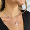 Close up view of model wearing the Simple Reminder Necklace in Silver which features silver double chain layer with a square design medallion.