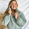 Front view of model wearing the Emerson Corduroy Puffer Jacket in Mint that has light green corduroy fabric, diamond stitching, zipper, a high neck, two front pockets, a drawstring hem, and long sleeves.