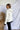 Back/side view of model wearing the Yosemite Puffer Jacket that has ivory puffer fabric, two front pockets, black zipper details, a zip-up front, and a hood. Worn over black top.