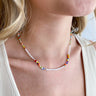 Close up view of model wearing the Full Of Fun Necklace which features multi color beads and pearl beads.