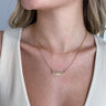 Close up view of model wearing the Take A Walk Necklace in Gold features gold double chain layer with a rectangle design medallion.