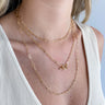 Close up view of model wearing the One Last Time Necklace which features triple layer with gold chain links and an open circle. 