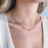 Close up view of model wearing the Break The Chain Necklace which features gold mini chain links with a clear stone.