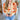 Close front view of model wearing the Happy With You Cardigan that has beige knit fabric, a dark orange and light orange flower pattern, a cropped waist, tortoise buttons, and long sleeves with beige ribbed wrists