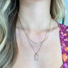 Close up view of model wearing the Simple Reminder Necklace in Gold features gold double chain layer with a square design medallion.