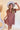 Front view of model wearing the Look At You Satin Dress that has terracotta satin fabric, two front chest pockets, v-neckline and cuffed short sleeves