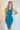 Front view view of model wearing the Over The Pines Dress which features dark green ribbed fabric, slit on the left side hem, round neckline and sleeveless.