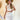 Full body front view of model wearing the Blank Space Dress that has cream knit fabric, a ribbed round neckline, a midriff cutout, and a sleeveless body