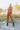Front view of model wearing the Live Fast Pants, which have a brown faux-leather material, a high-rise fit, a front button and zipper closure, and a straight leg fit. Worn with matching top.
