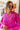 Front view of model wearing The Magenta Haze Sweater features a magenta pink colored knit material, an oversized collar, a V neckline, long cuffed sleeves, and a thick bottom hem.