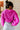 Back view of model wearing The Magenta Haze Sweater features a magenta pink colored knit material, an oversized collar, a V neckline, long cuffed sleeves, and a thick bottom hem.