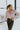 Frontal view of the One Thing Bodysuit that features a dark mauve color, a surplice neckline, a puffy sheer long sleeve, a bikini bottom, and a snap closure.